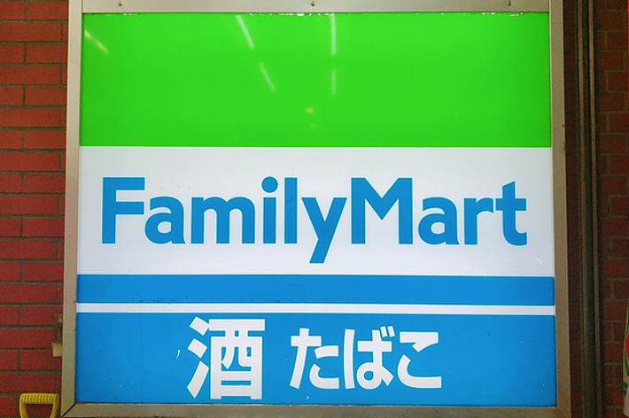 ファミリーマートの看板、緑と白と青の背景に「Family Mart」と「酒 たばこ」の文字が書かれています。