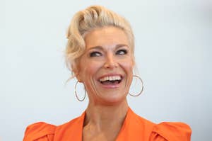 Hannah Waddingham smiling, wearing a stylish outfit with puffed shoulder sleeves and large hoop earrings