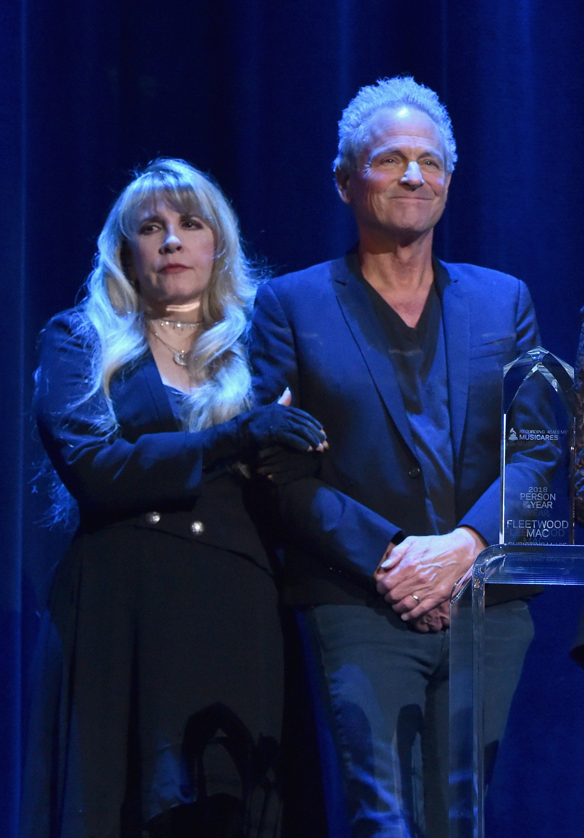 Stevie onstage with her arms linked through Lindsey's