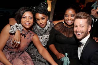 Taraji P. Henson, Janelle Monáe, Octavia Spencer, and Glen Powell celebrate at an event, holding a statuette. They are dressed in elegant evening attire