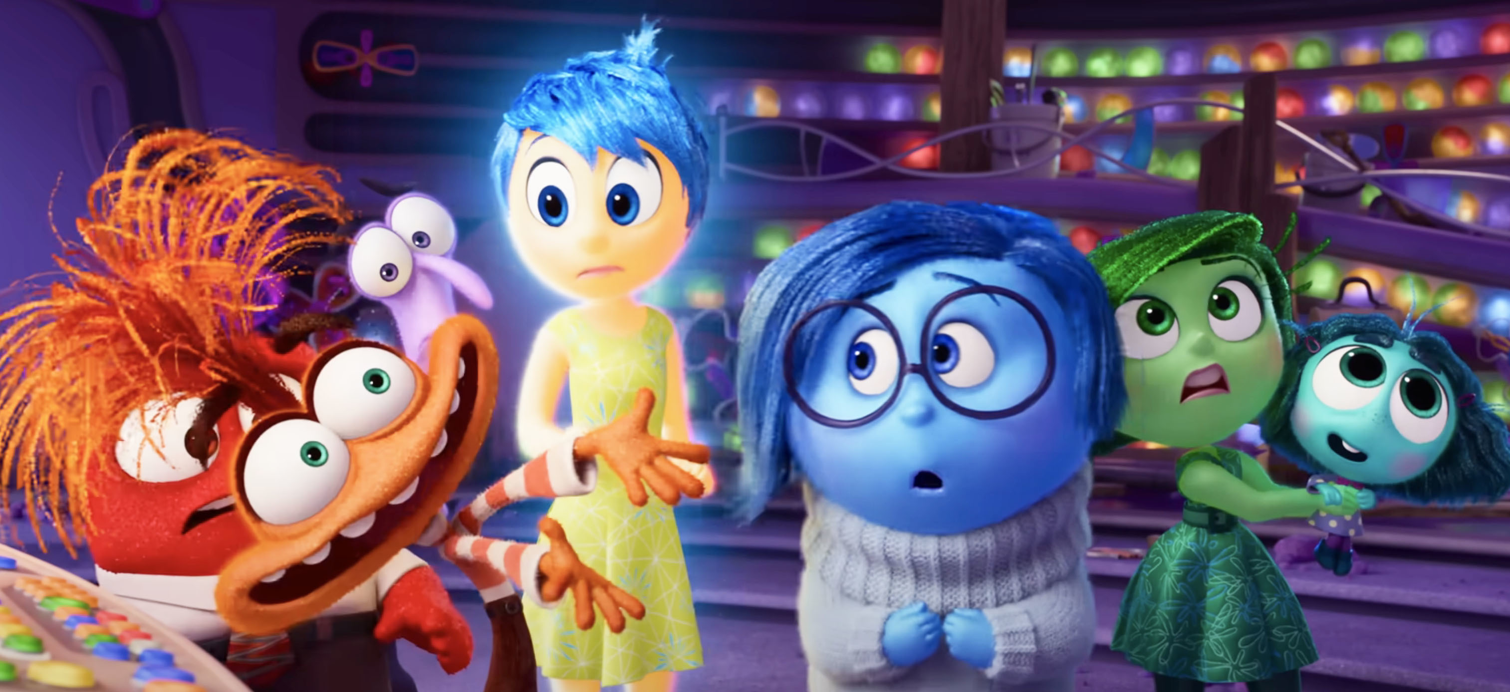 Characters from Inside Out including Anger, Joy, Sadness, Disgust, and Fear stand together with colorful lights in the background