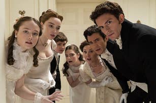 Bridgerton cast in period costumes gathered closely, looking with surprise: Florence Hunt, Phoebe Dynevor, Luke Newton, Claudia Jessie, Ruth Gemmell, Luke Thompson, Jonathan Bailey