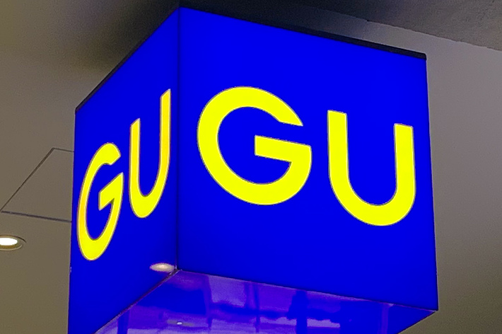 ショップの青いサインに「GU」という黄色い文字が表示されています。