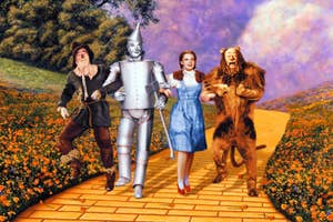Dorothy, Scarecrow, Tin Man, and Cowardly Lion walk arm-in-arm down the Yellow Brick Road in a scene from "The Wizard of Oz."