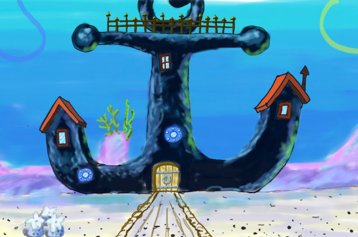 图片显示了一个锚形状的水下房屋，有窗户和门。它周围是水下植物和沙地上的两个气泡