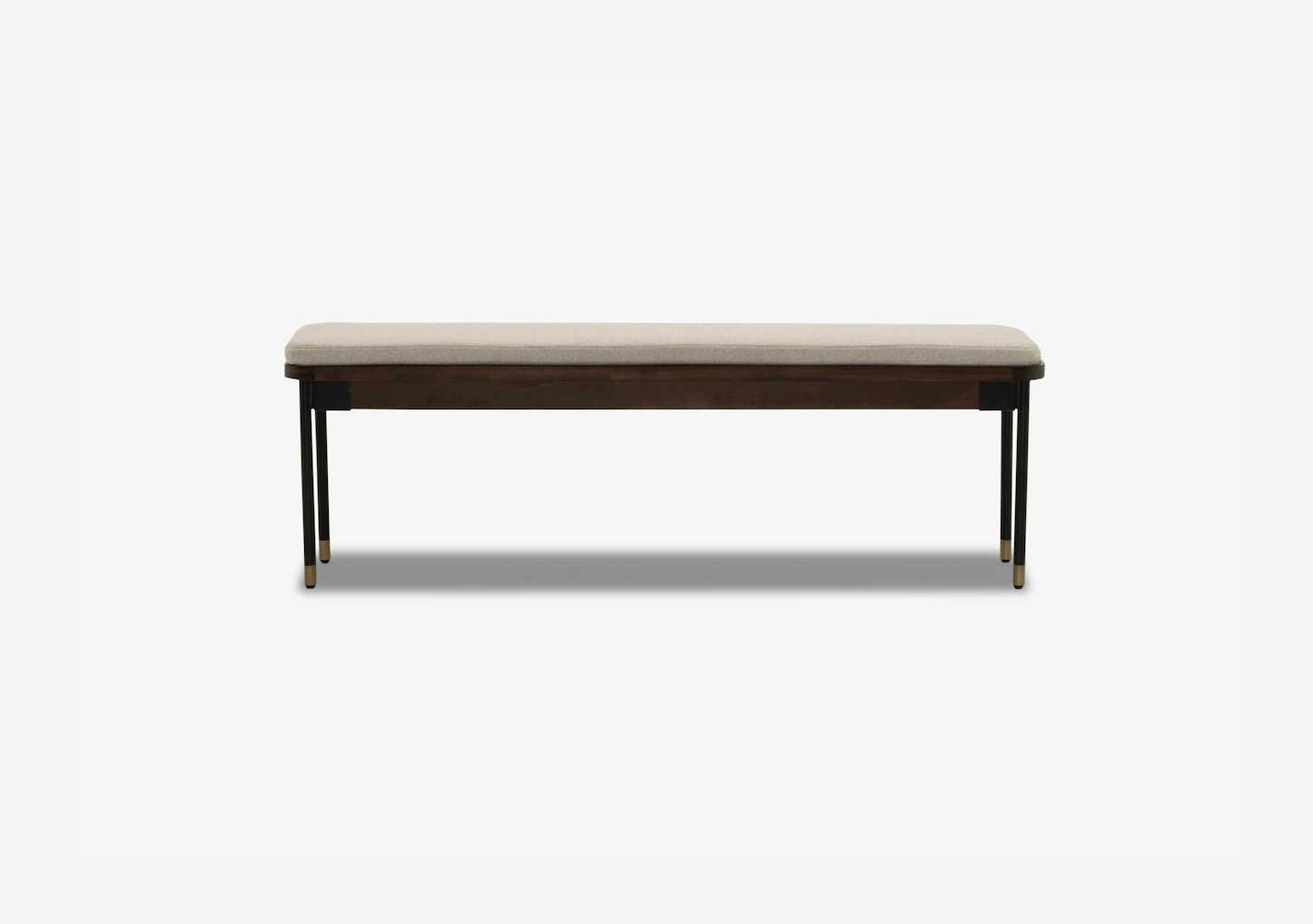 A modern backless bench with a cushioned seat, dark wooden frame, and sleek metal legs, suitable for home decor or shopping