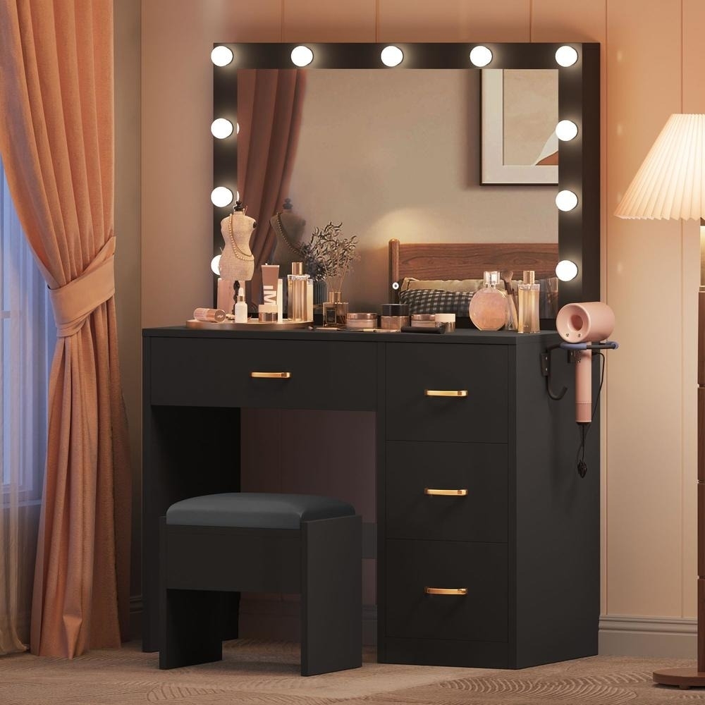 Makeup vanity set with illuminated mirror, storage drawers, stool, and various cosmetics arranged on the tabletop. Lamps and curtains enhance the cozy ambiance