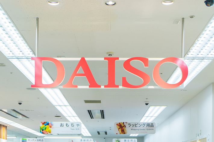 人々が商品を眺めているダイソー店内の様子。ハロウィン装飾や様々な商品が展示されている。