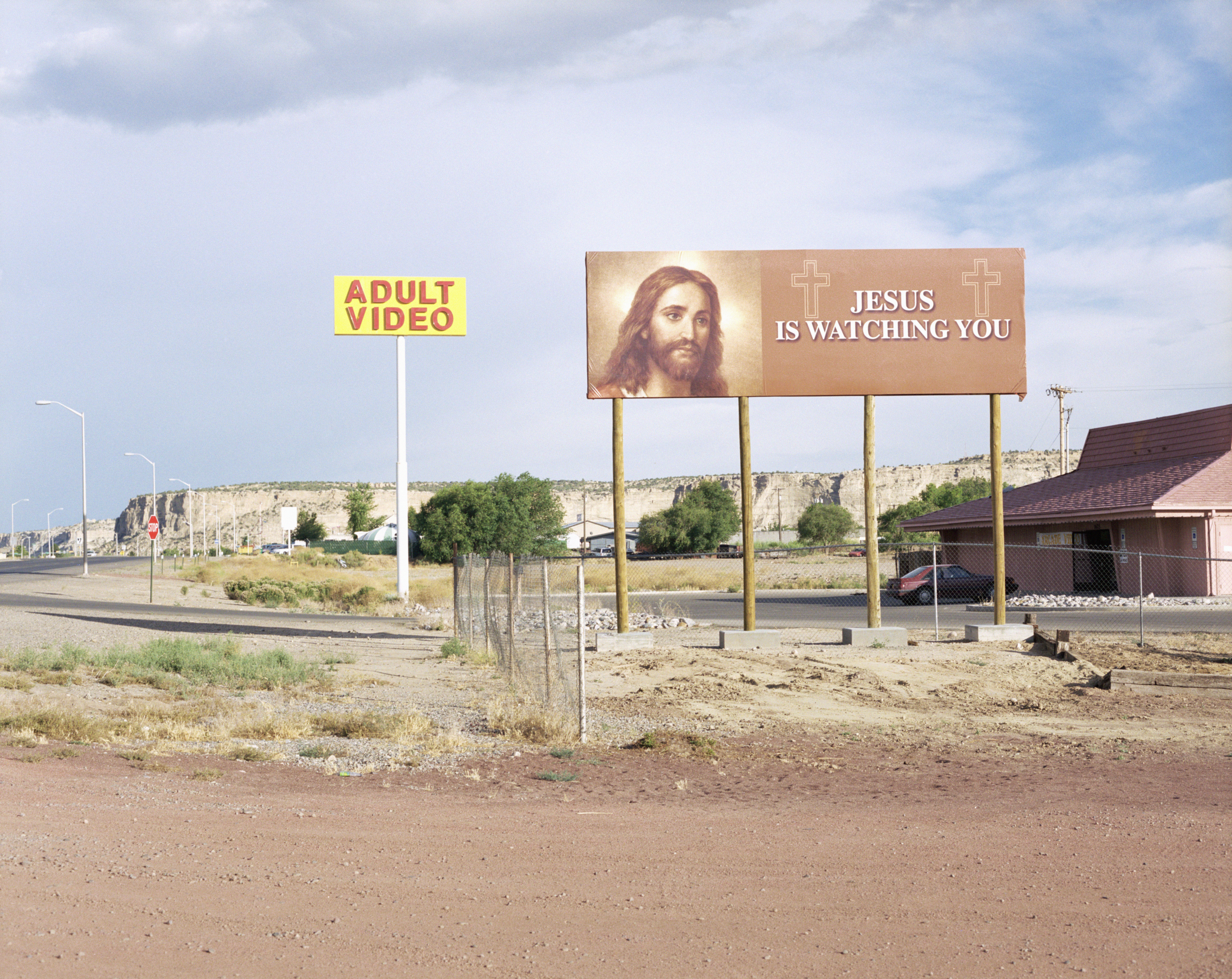 Billboard near an &quot;Adult Video&quot; store displays an image of Jesus with the text &quot;JESUS IS WATCHING YOU&quot;