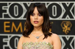 Jenna Ortega poses in a floral gown with a diamond necklace at a FOX event backdrop