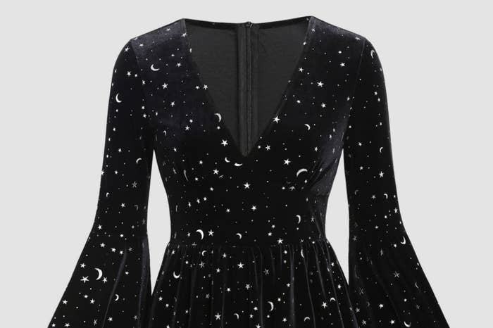 Black dress with a V-neckline and flared sleeves, featuring a pattern of stars and crescent moons