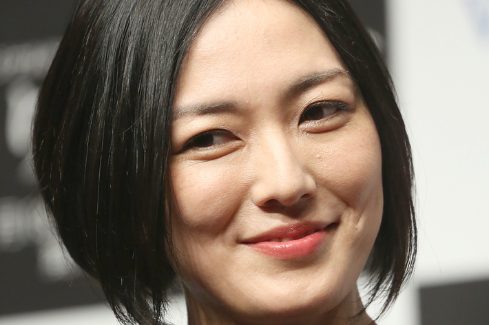 女性が微笑んでいる近影。黒いトップスを着ている。