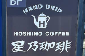 手淹れコーヒーの看板で、「HAND DRIP HOSHINO COFFEE 星乃珈琲店」と書かれています。