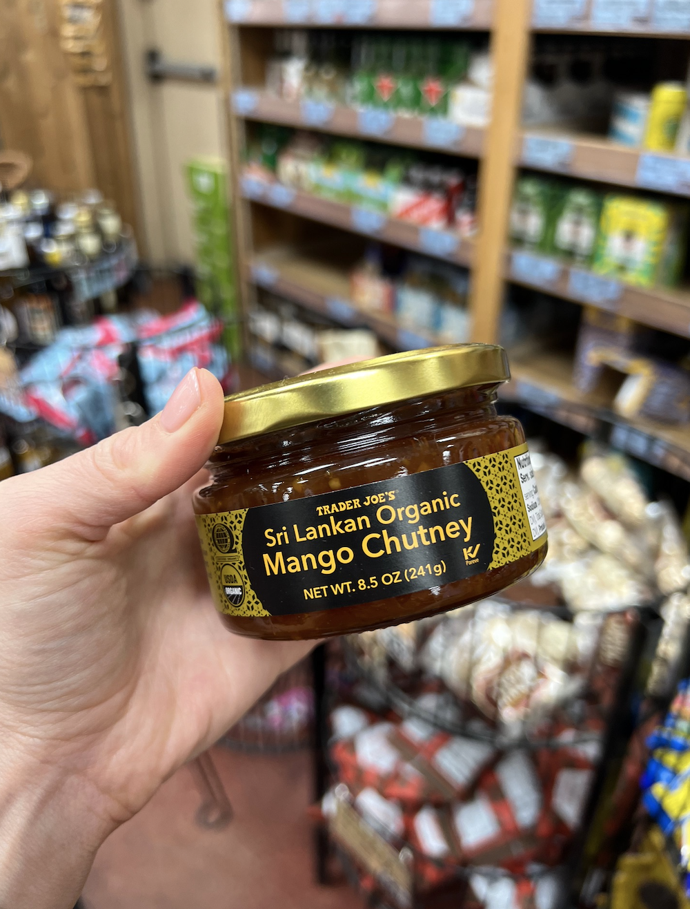 A hand holds a jar of Trader Joe's Sri Lankan Organic Mango Chutney