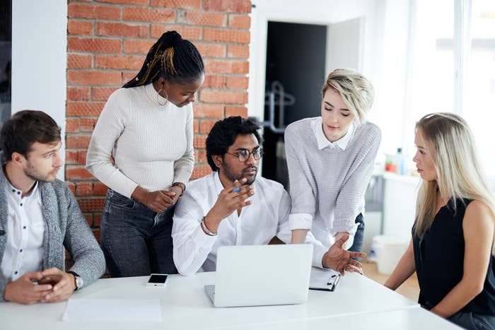 Five people around a table collaborating