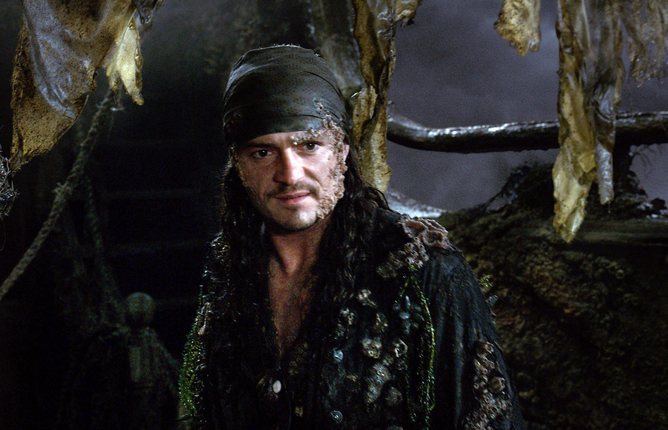 Orlando Bloom as Will Turner in pirate attire with weathered skin in a scene