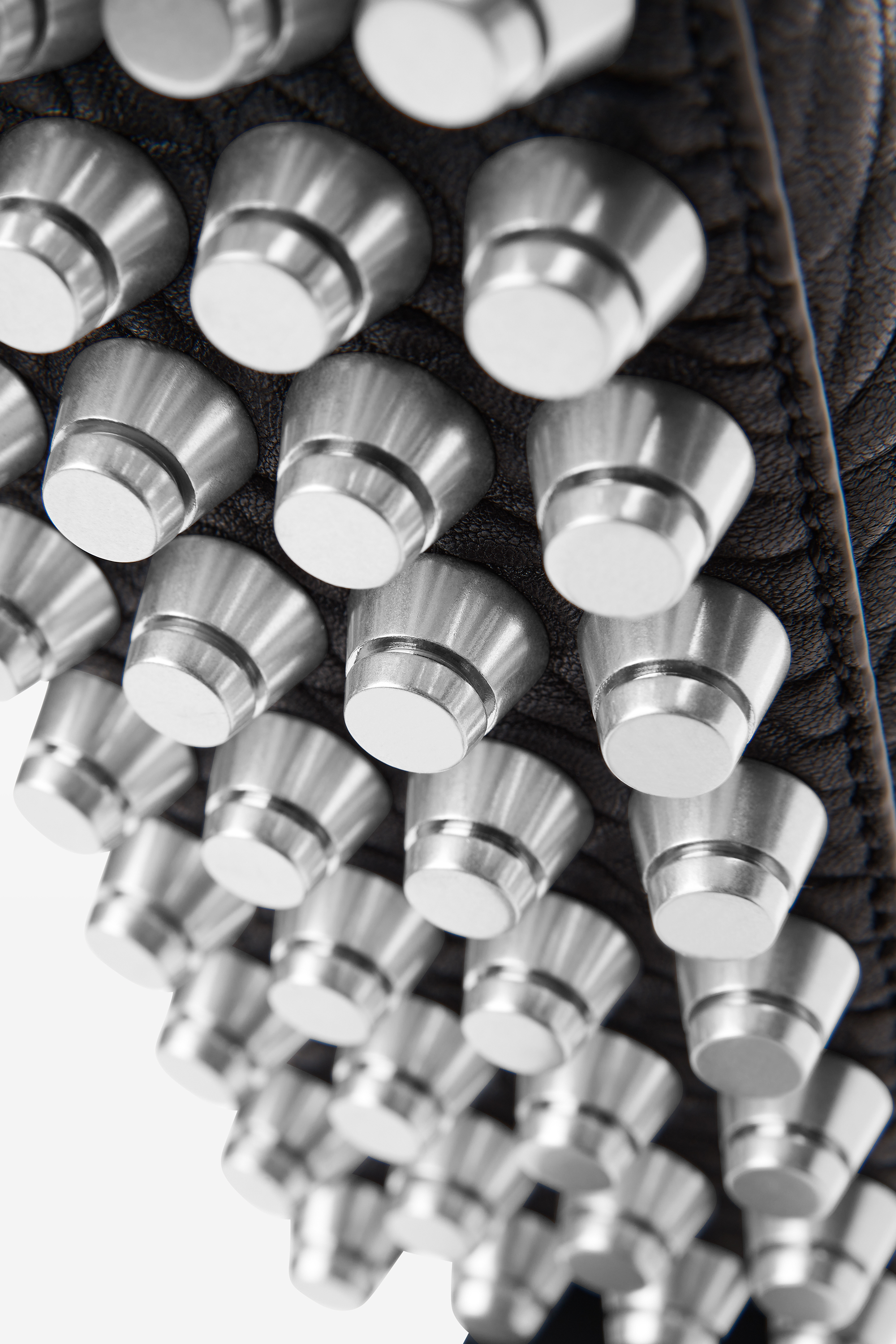 Close-up of a designer bag featuring numerous metallic studs arranged in uniform rows