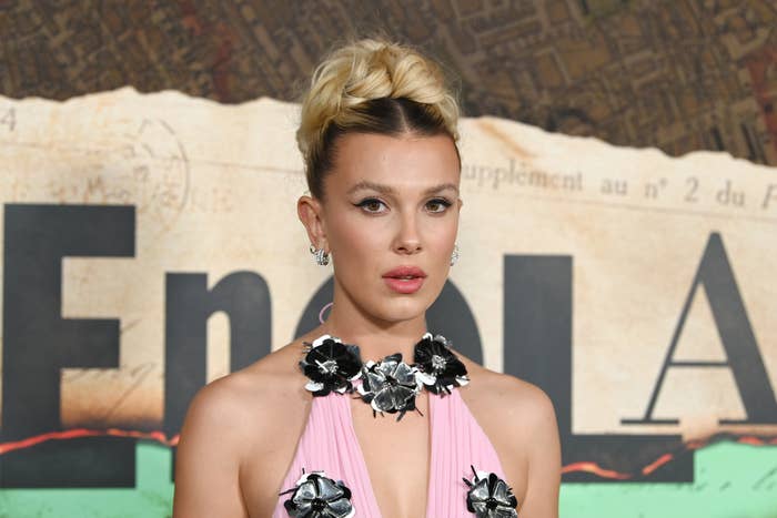 Millie Bobby Brown in an elegant dress with floral embellishments at an Enola Holmes event