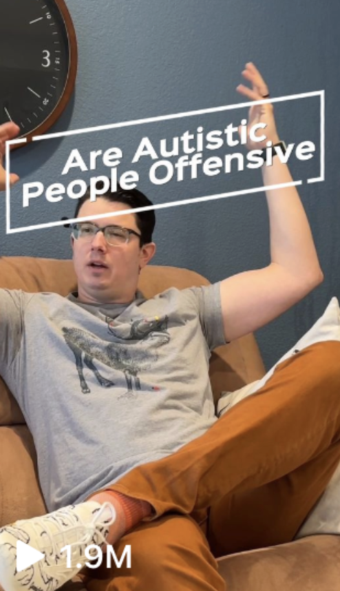 Person wearing glasses, a graphic t-shirt, and brown pants, sitting on a couch with animated expression. Text reads: "Are Autistic People Offensive." Video has 1.9 million views