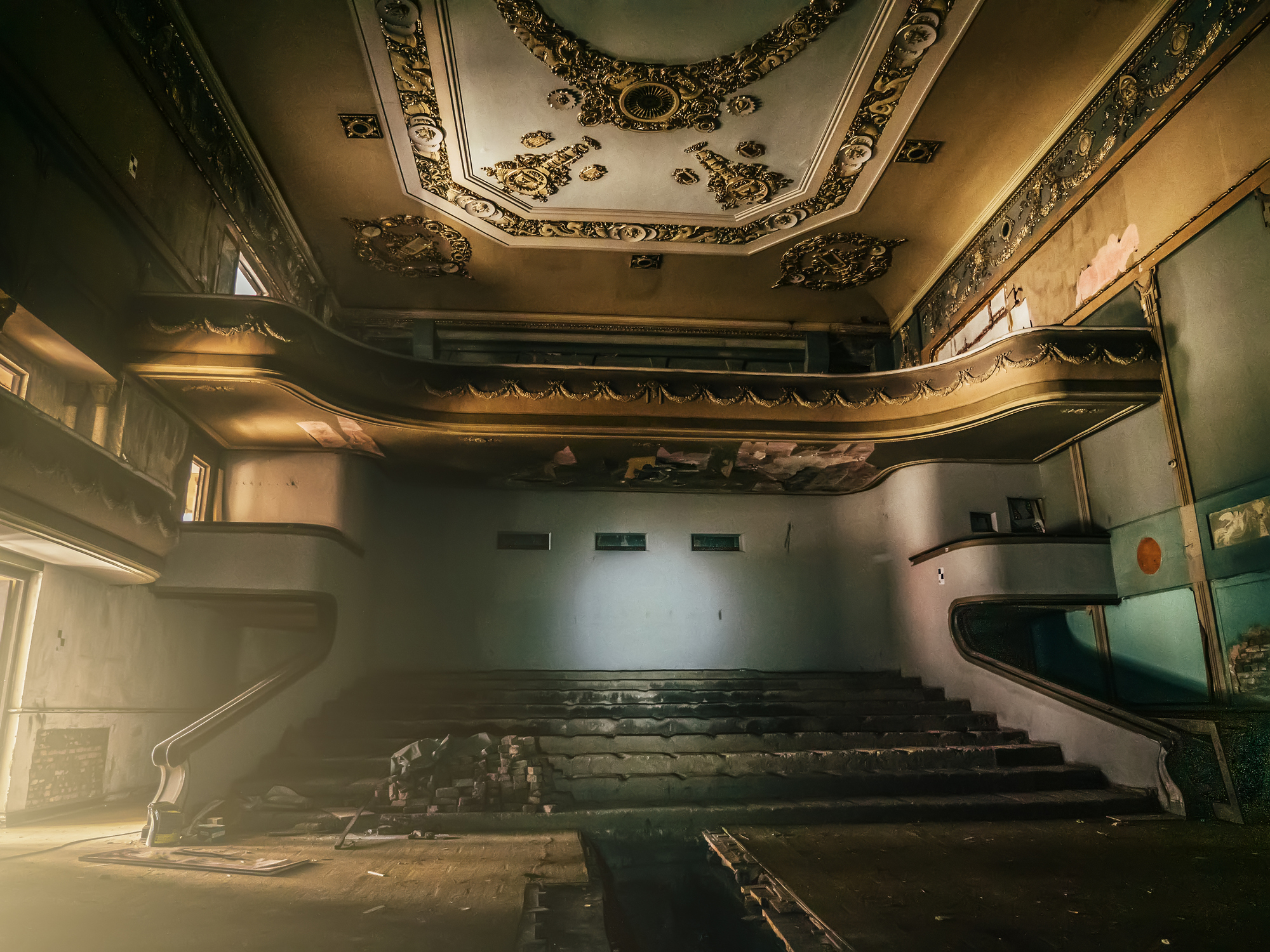 Ornate, neglected theater with peeling paint and broken seats, found on the Internet