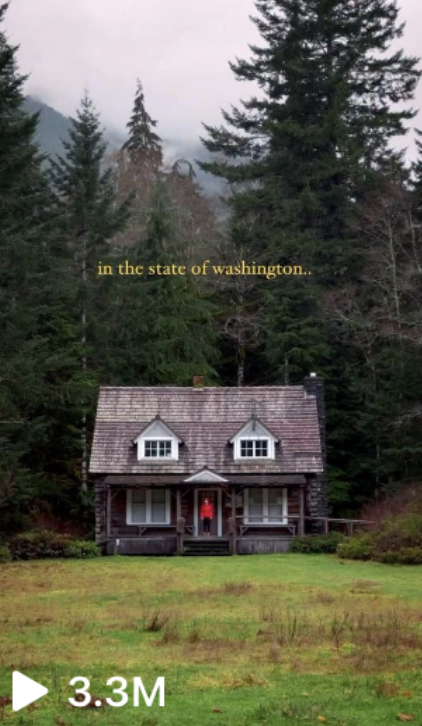 A cozy cottage surrounded by tall trees in the state of Washington with a person in a red shirt standing on the porch. The video has 3.3M views