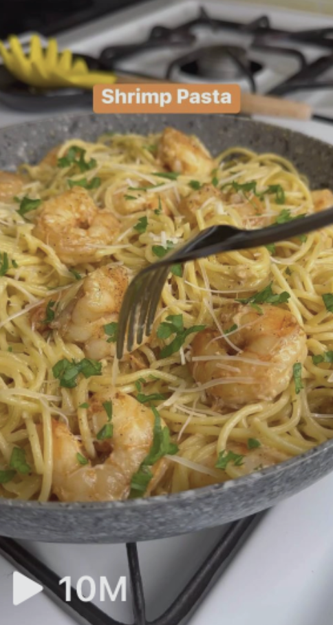 Shrimp pasta dish topped with parsley and grated cheese in a pan with a fork lifting some pasta. Text overlay reads "Shrimp Pasta." Video has 10 million views