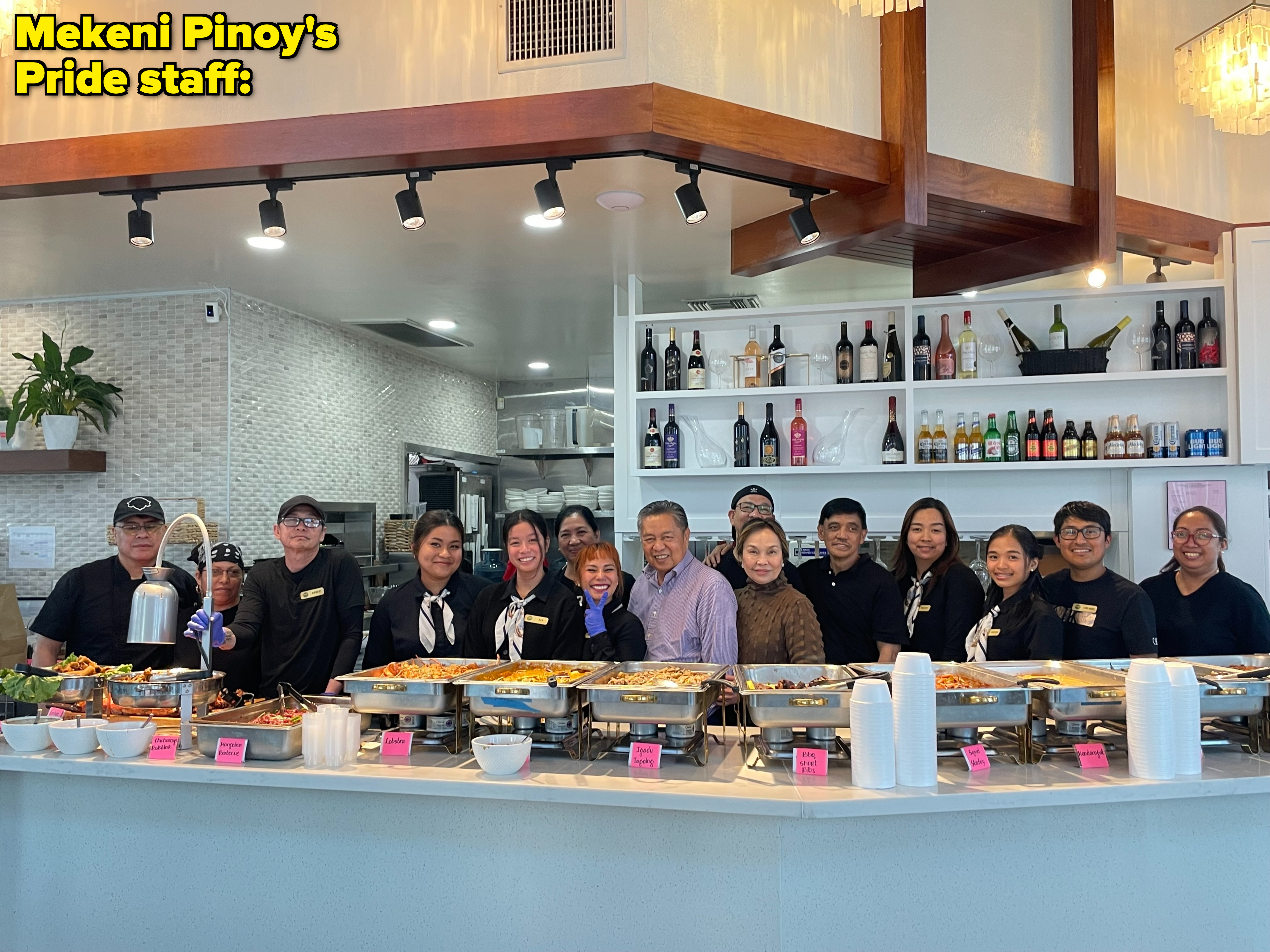 A group of restaurant staff, including Chef Jai, stand behind a counter with various dishes on display, ready to serve a buffet-style meal