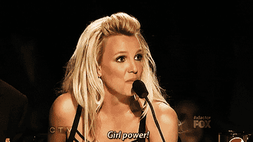 Britney Spears at a judging panel, saying "Girl power!" into a microphone