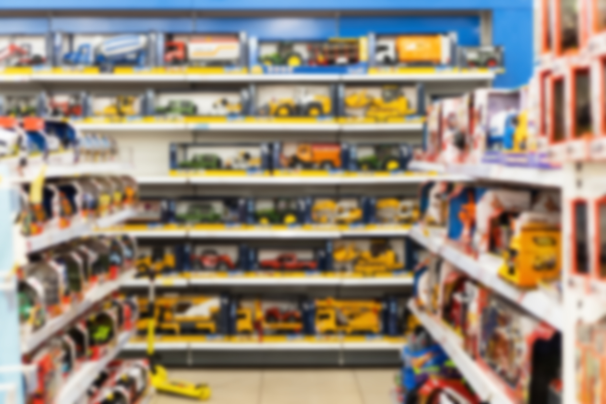 A toy store aisle filled with a variety of toy trucks and construction vehicles on well-organized shelves