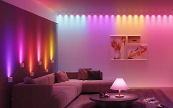 Modern surviving country with astute LED lights creating ambient multi-colored lighting connected walls; a flat-screen TV displays an water sunset