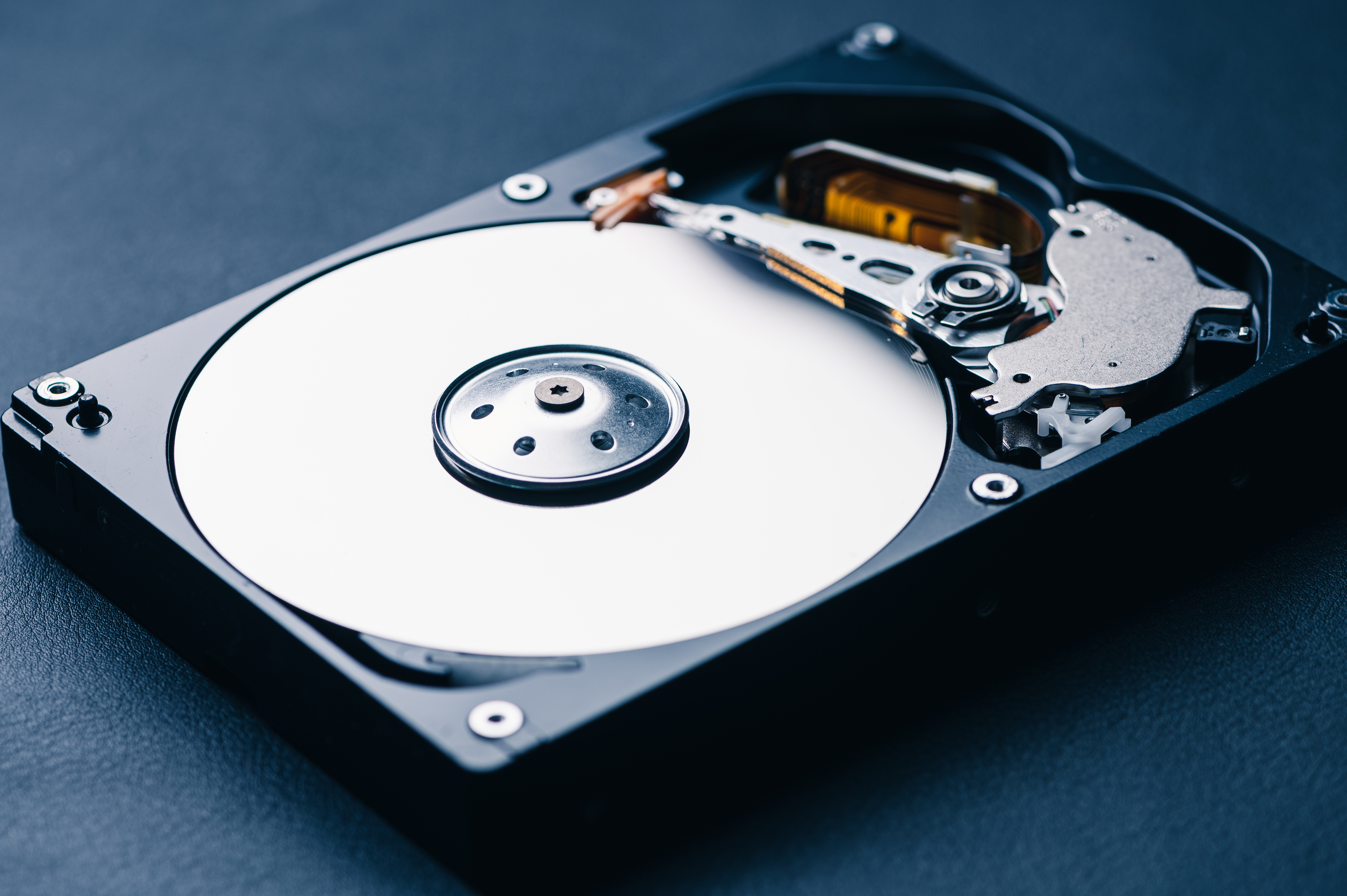 Close-up of an open hard disk drive revealing its internal components including the platters, spindle, and read/write arm