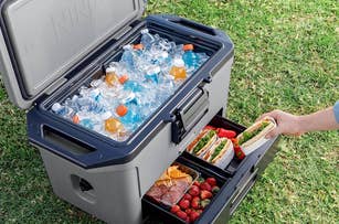 cooler with ice and drinks in top part and snacks in bottom drawer