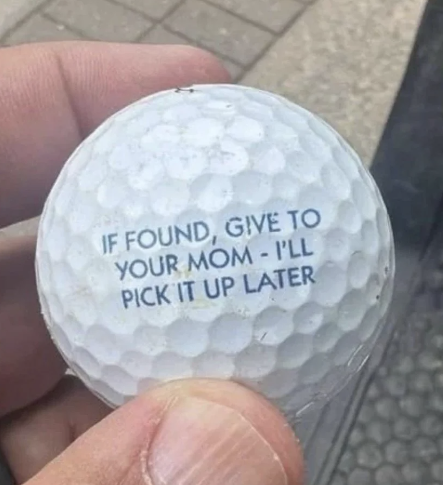 A person holds a golf ball with the text: "IF FOUND, GIVE TO YOUR MOM - I'LL PICK IT UP LATER."