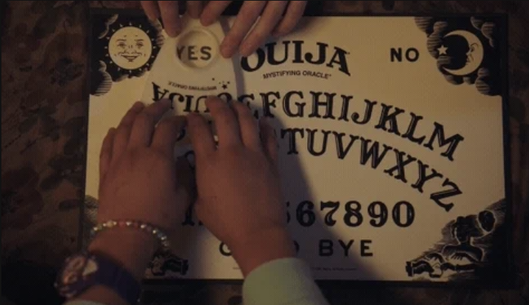 Hands using a Ouija board