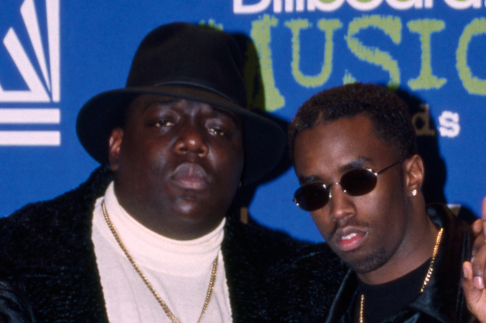 The image shows The Notorious B.I.G in a turtleneck and black hat, posing with Sean "Diddy" Combs, wearing sunglasses, at the Billboard Music Awards