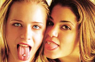 Two people with tongue piercings smiling and sticking out their tongues