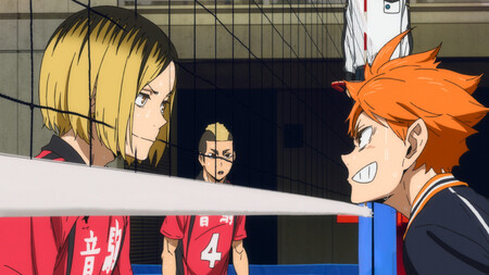 Kozume Kenma y Shoyo Hinata se miran intensamente a través de la red de voleibol durante un partido. Kuroo Tetsurou observa desde el fondo
