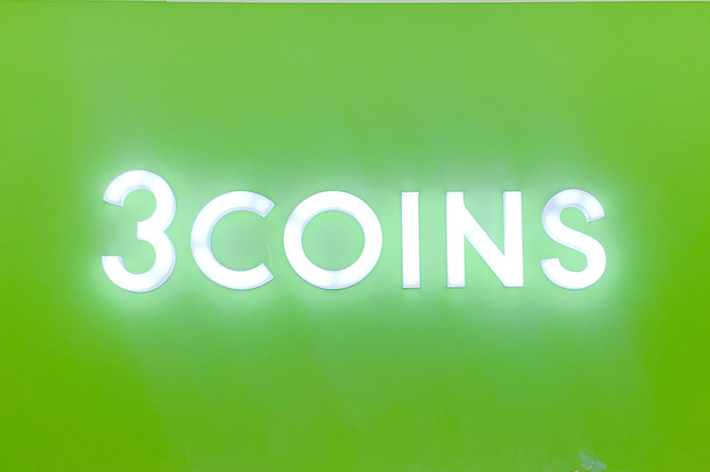 緑色の背景に「3COINS」と書かれた電光サイン。