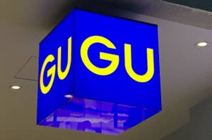A cubic sign with the text "GU GU" hanging from the ceiling