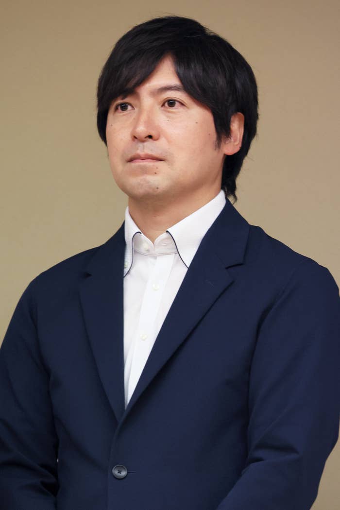 男性がスーツを着て直立している。