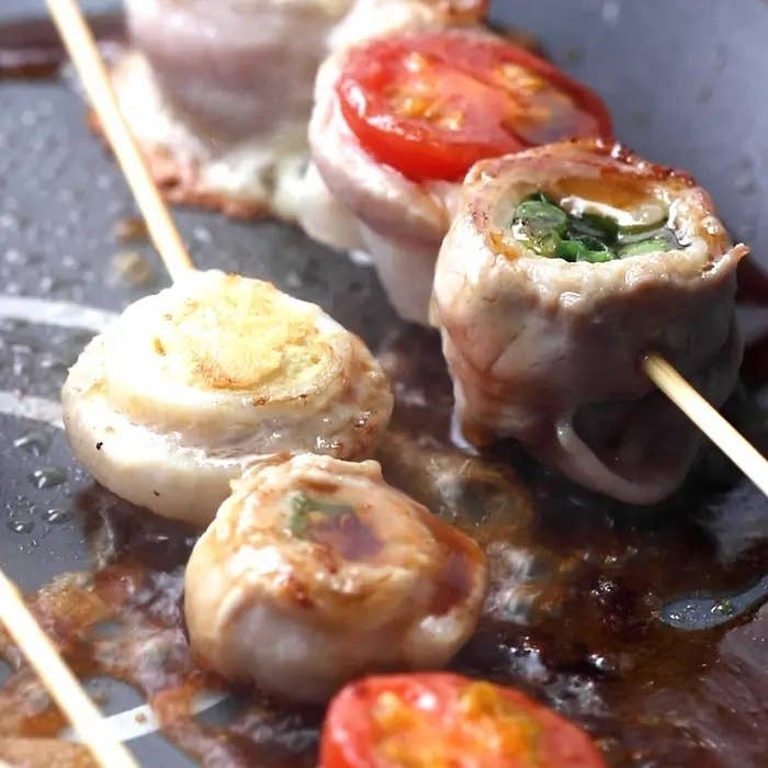 調理中の串焼き料理。野菜が串に刺さっています。