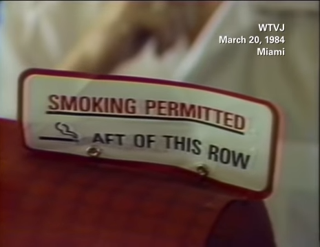Sign on airplane seat reading &quot;SMOKING PERMITTED AFT OF THIS ROW&quot; with date March 20, 1984, from WTVJ Miami