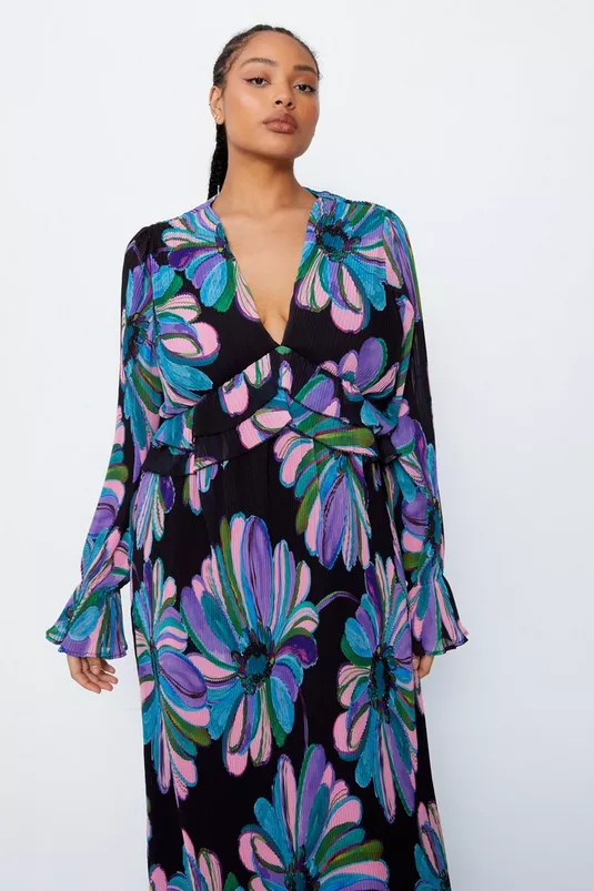 Woman modeling a floral print dress with ruffle details, suitable for shopping category