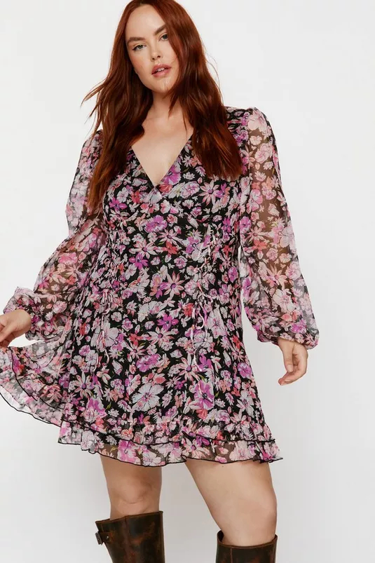 Woman in a floral dress with sheer sleeves twirling, perfect for spring fashion