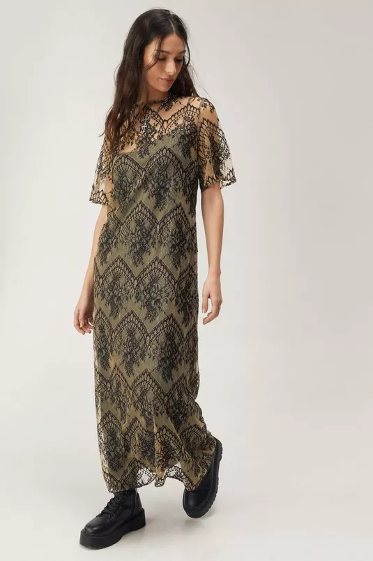 Woman models lace midi dress with short sleeves and floral pattern, paired with black shoes