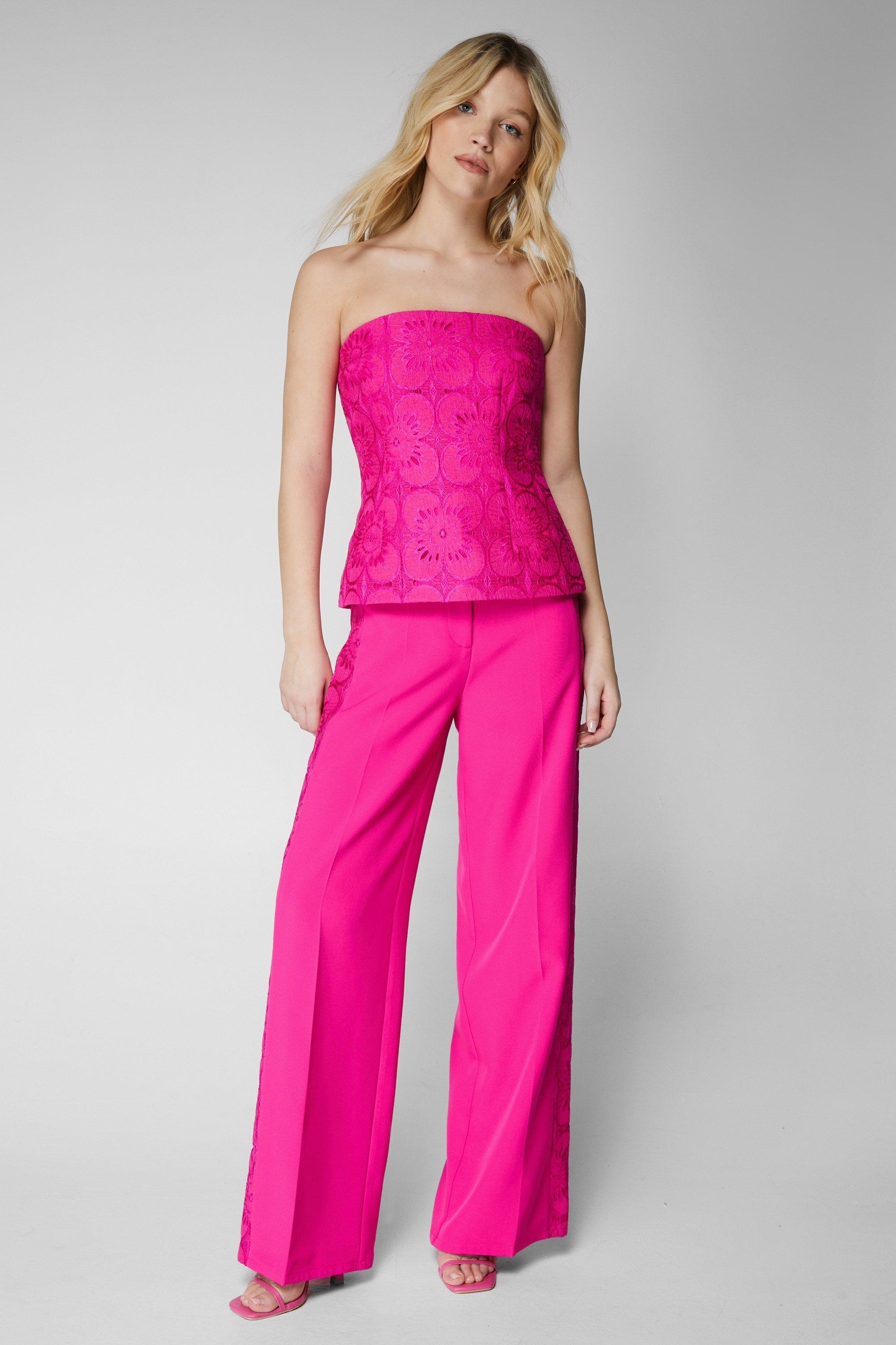 Model wearing a strapless pink peplum top and matching wide-leg trousers