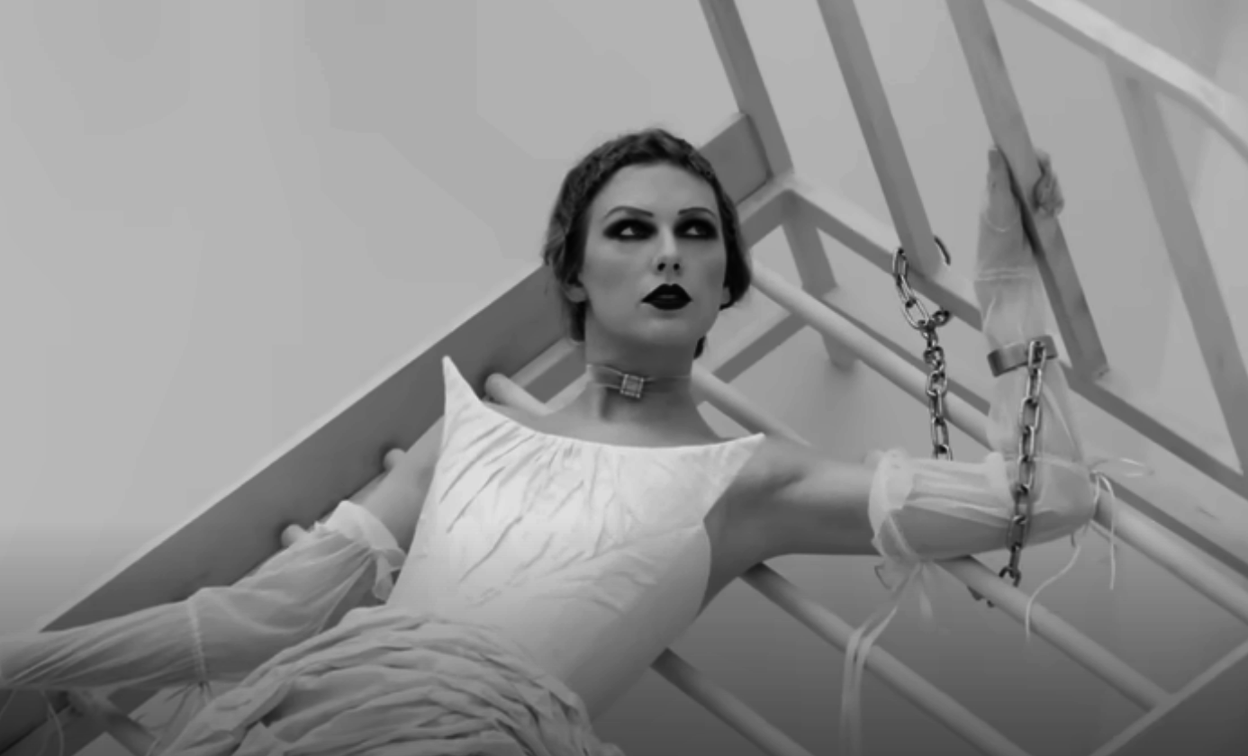 Woman in vintage style dress with chained wrists, dramatic makeup, posing artistically with geometric background
