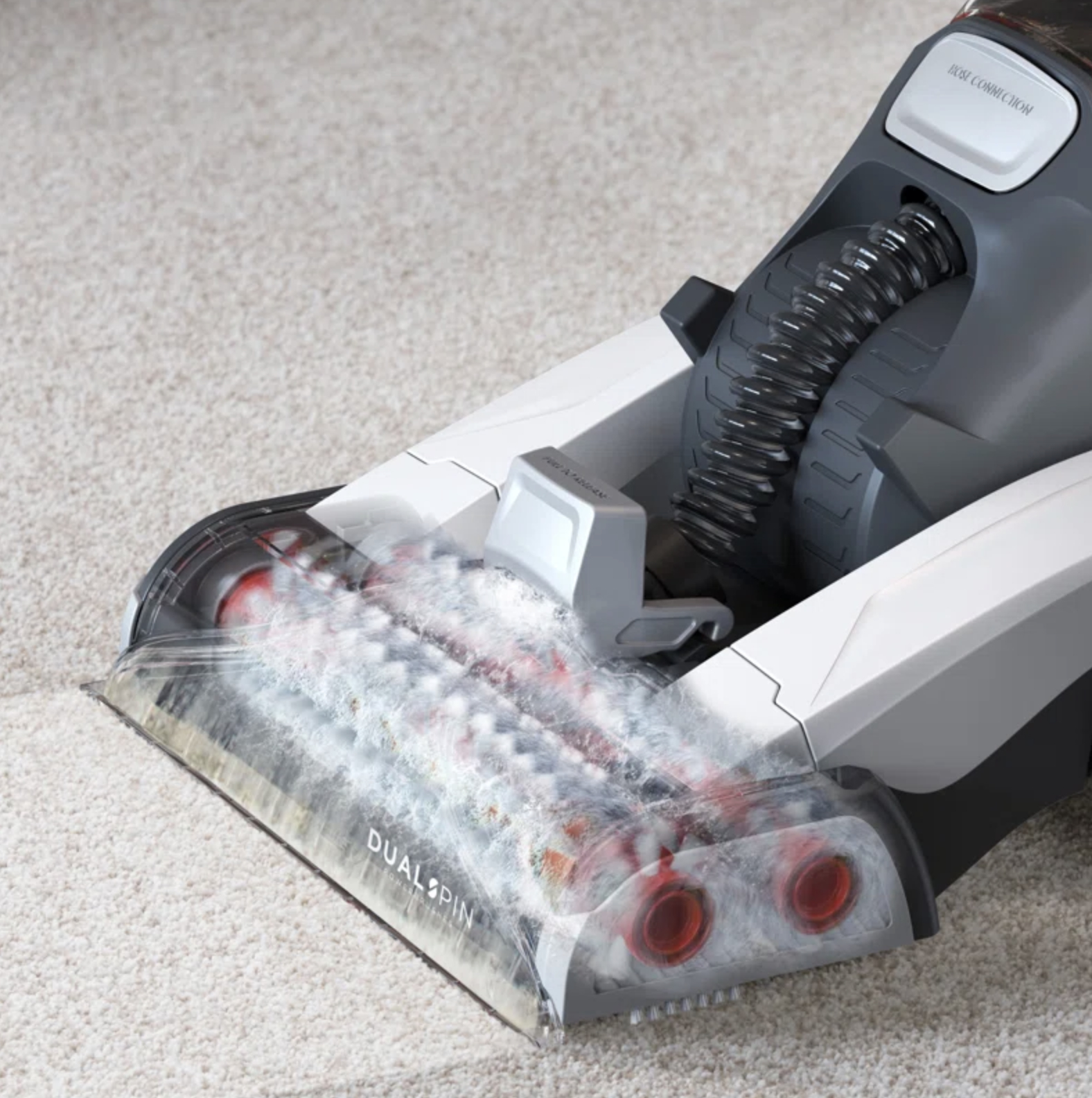 Vacuum cleaner head cleaning a carpet, showing clear suction path and debris being collected