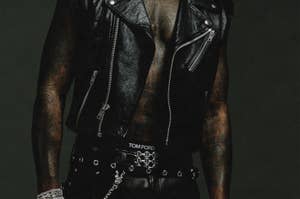 Music artist in a studded leather jacket, chain belt, and layered necklaces