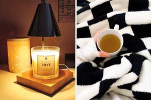 Person's hand holding a white mug against a black and white patterned blanket, and a lit candle on a bedside table